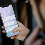 Image of a man holding a phone displaying screen notifications