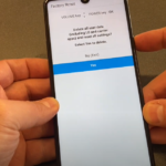 A hand holding an LG Stylo 6 smartphone showing the factory reset screen