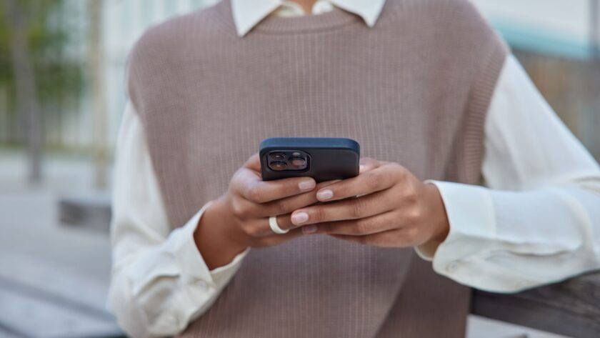 a black woman in elegant clothes holding a mobile phone