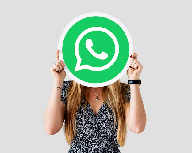A girl holding an icon of the WhatsApp application