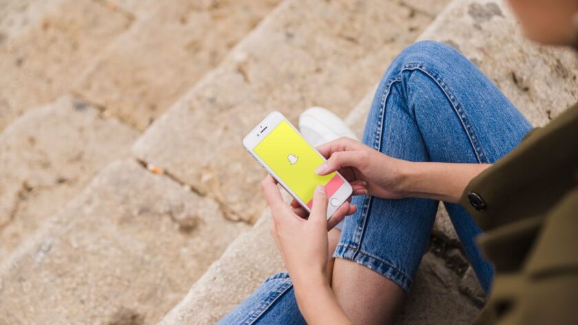 Woman sitting and using snapchat app