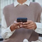 a black woman in elegant clothes holding a mobile phone